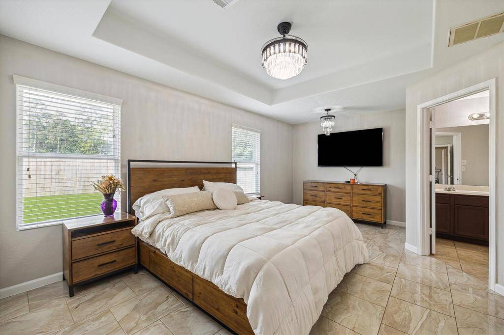 The extra large primary suite features a tray ceiling and large windows