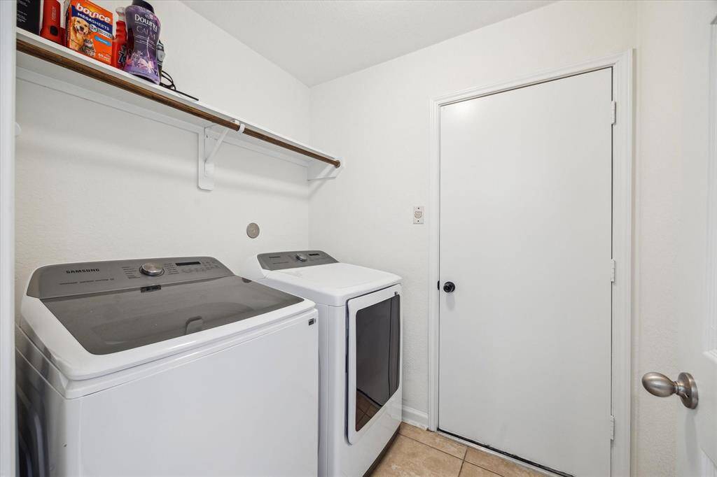 Laundry room (with access to the garage) features a storage shelf and hanging rod