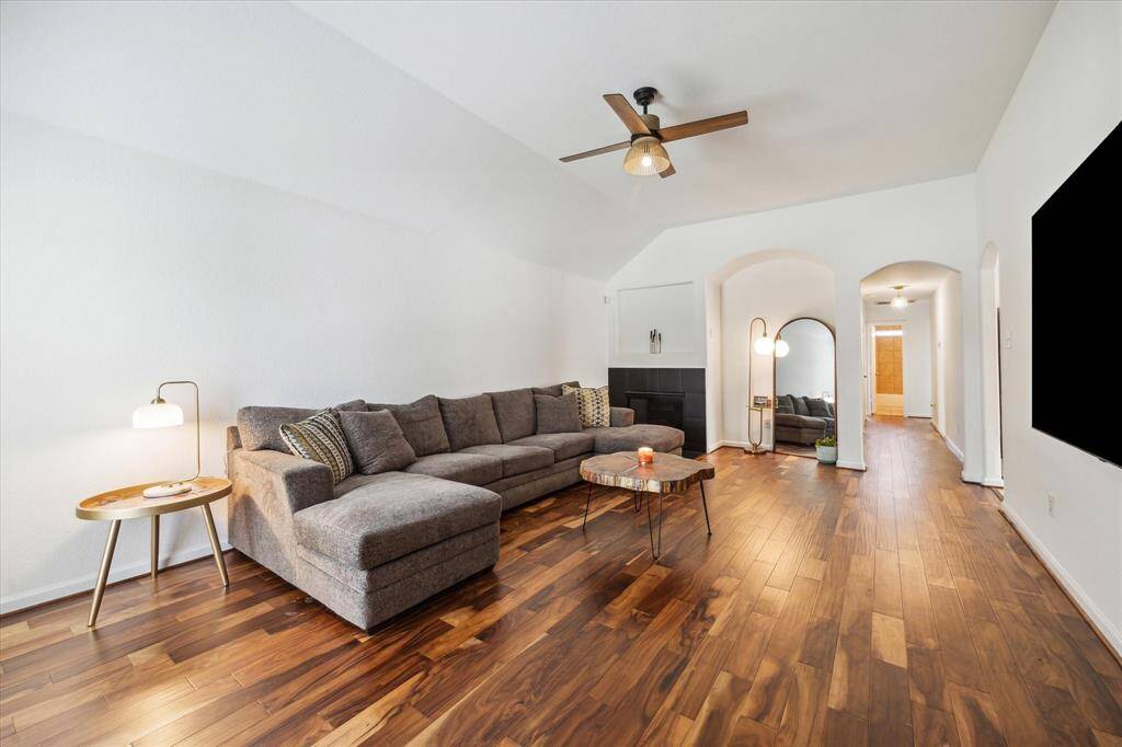 A gas fireplace, rich wood floors and a rounded art niche complete the space