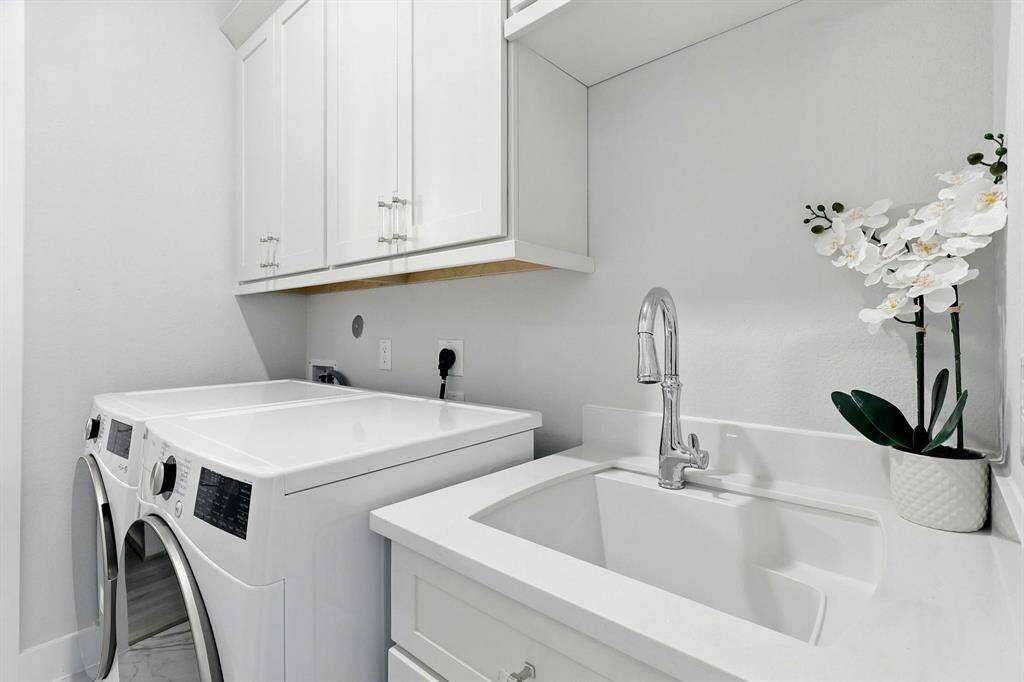 Spacious modern home office with light wood flooring and neutral walls. It features a large window with blinds, Minimalist decor will complements the clean and organized space.