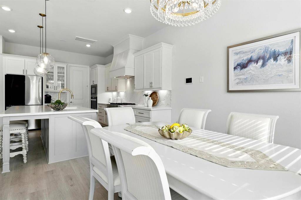 The dining area features a stylish chandelier and contemporary artwork, creating a welcoming atmosphere.