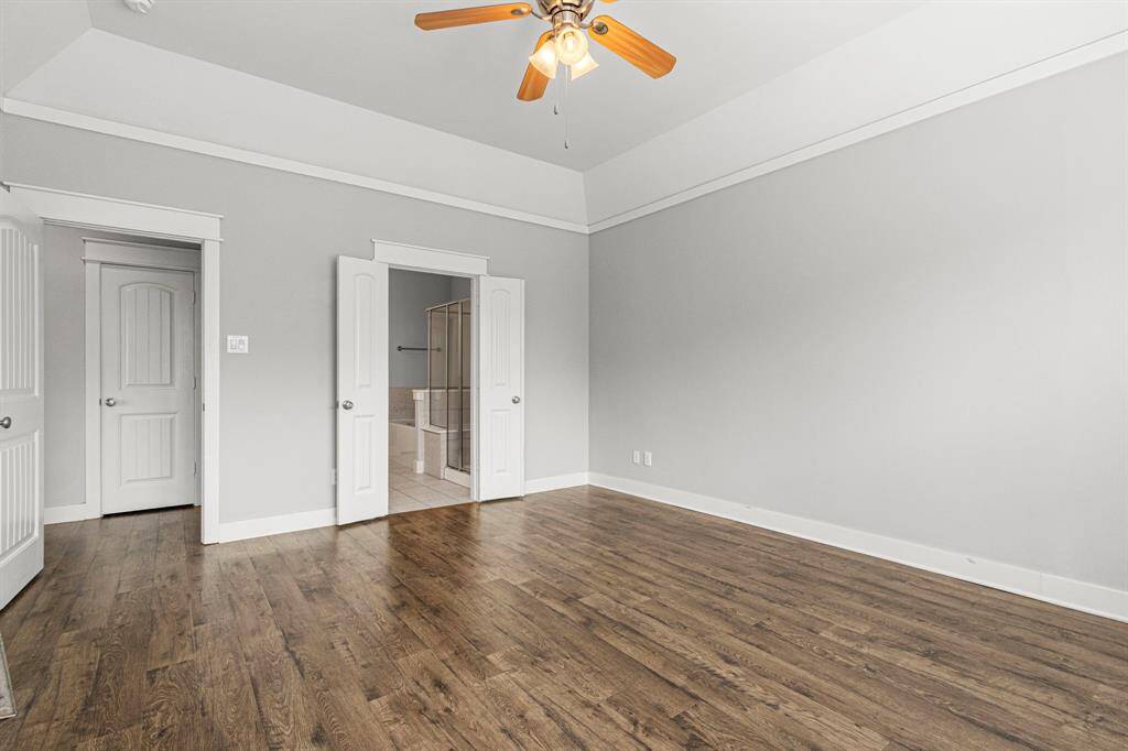 Another view of the primary bedroom showcasing the door to the attached bathroom.