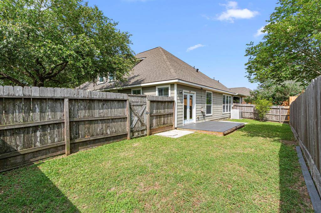 This photo shows the charming fence-enclosed backyard. The yard offers a private, serene outdoor space.