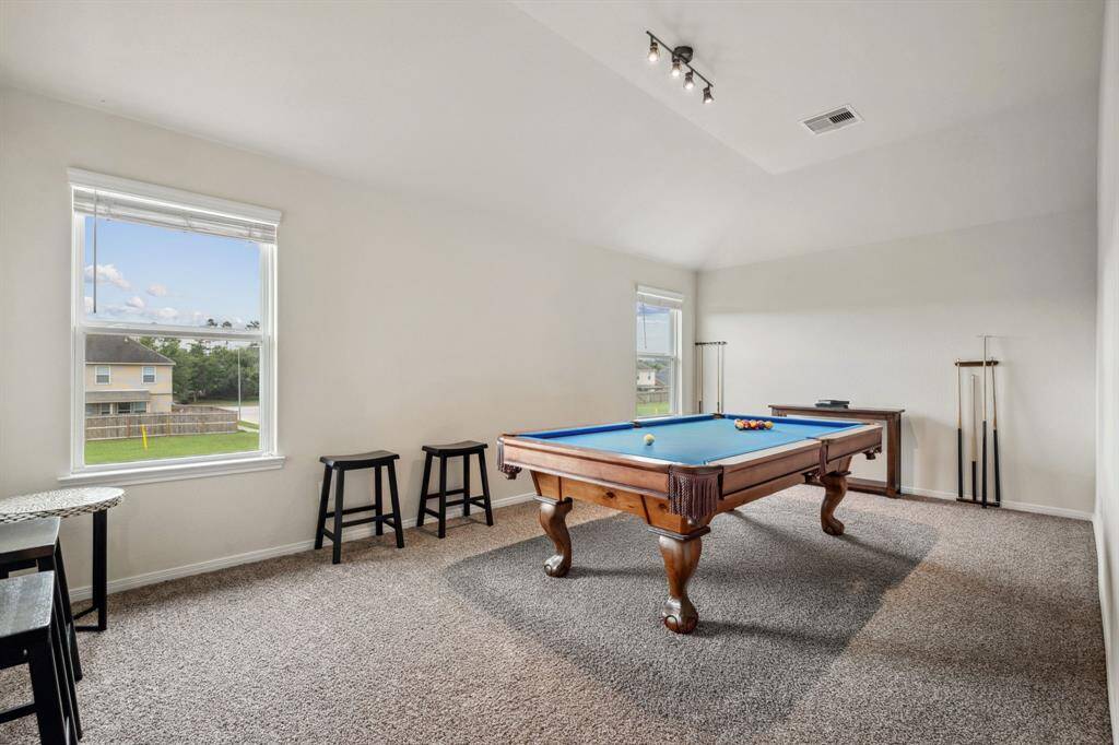 The home has a huge garme room, perfect for a game of pool or movie night. This Billard Factory pool table , accessories and barstools/table will be sold with the home