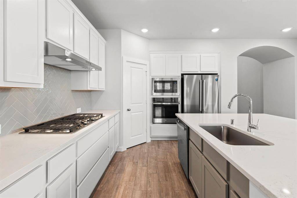 The kitchen is characterized by classic yet stylish style, including the traditional herringbone back splash and the white shaker cabinets.
