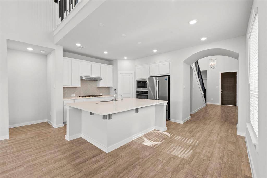 As you enter the house you will be grated by architectural arches that leads to the open floor plan, starting with the kitchen.