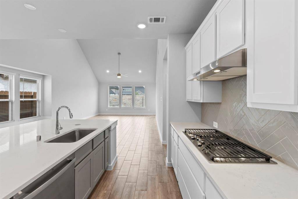 The big island includes modern conveniences like a big kitchen sink, SS dishwasher, and pop-up electric outlets on the island itself.