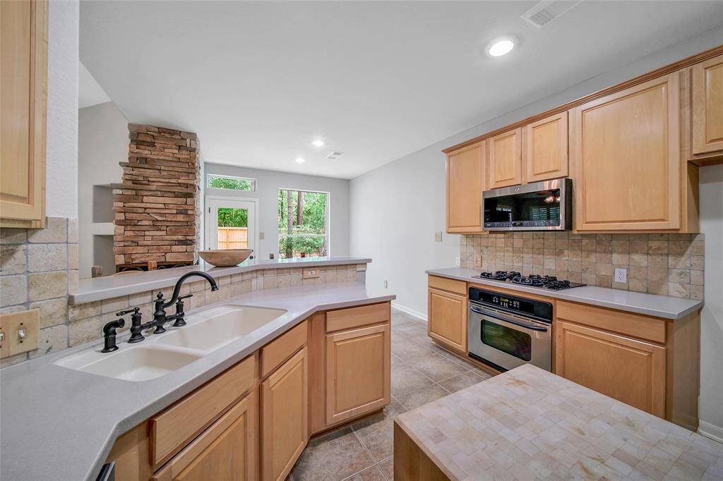 Stainless steel appliances include a gas cooktop and electric range.