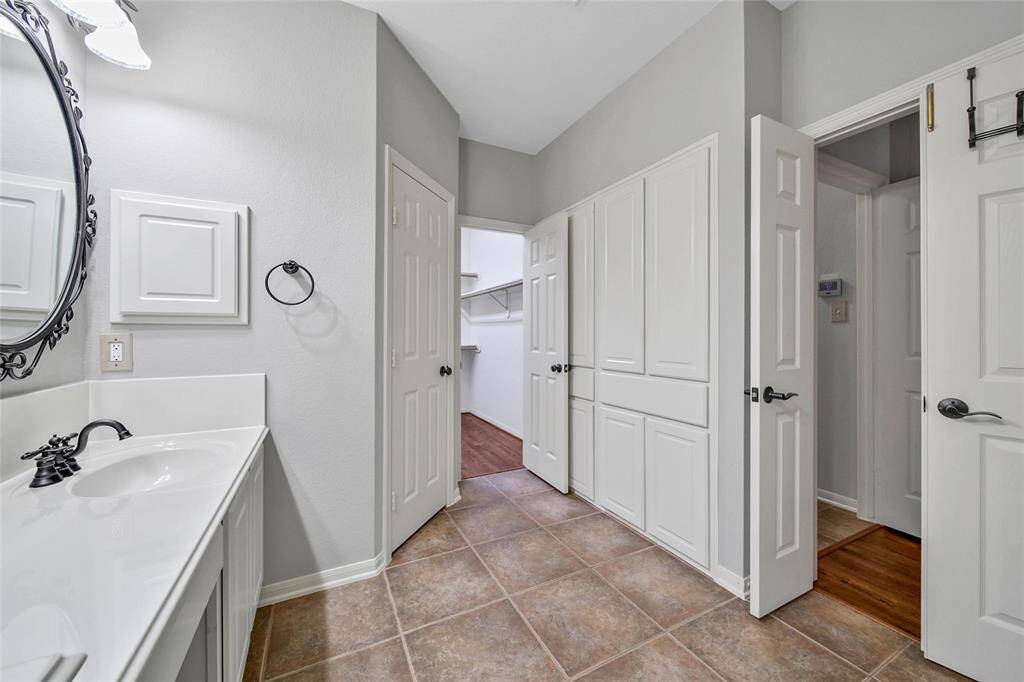 The built-in linen cabinets provide excellent storage and the lower cabinets are set up for discrete laundry basket storage with drop front panels above.