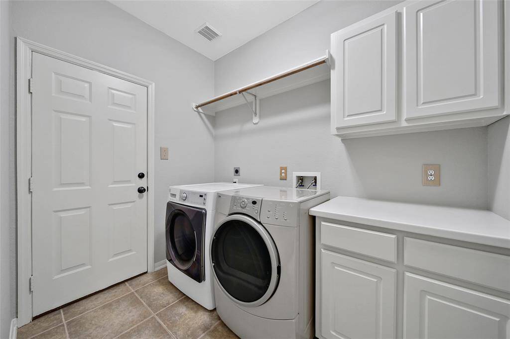 The laundry room offers space for folding, storage, and hanging space. Along with room beside your machines for taller items.