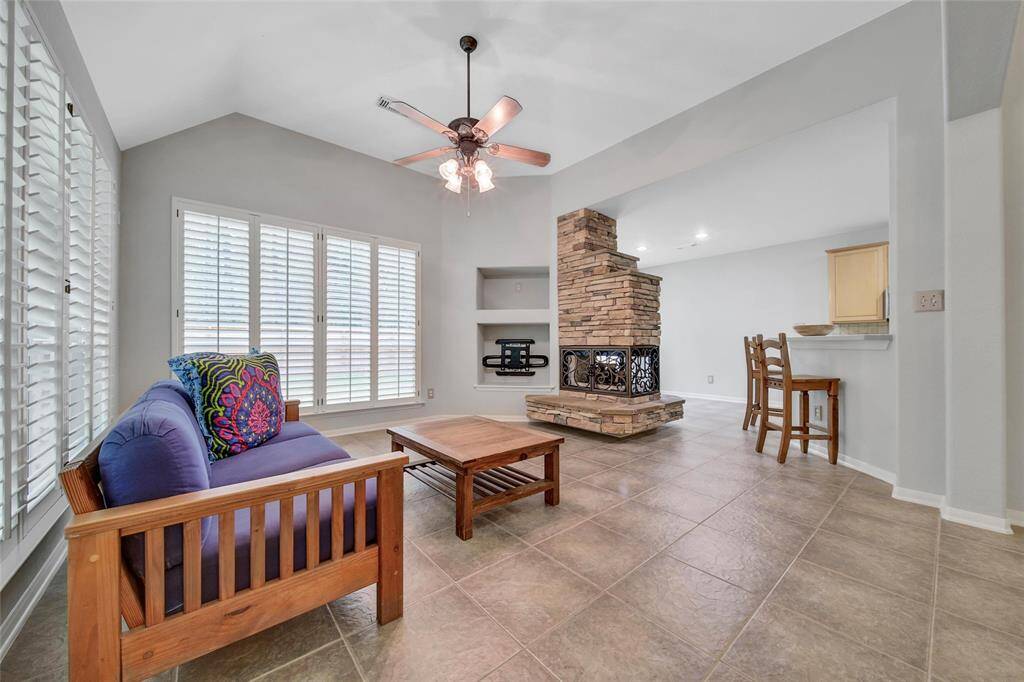 The family room is stunning with a two-sided stone gaslog fireplace and wrap-around corner windows with plantation shutters.