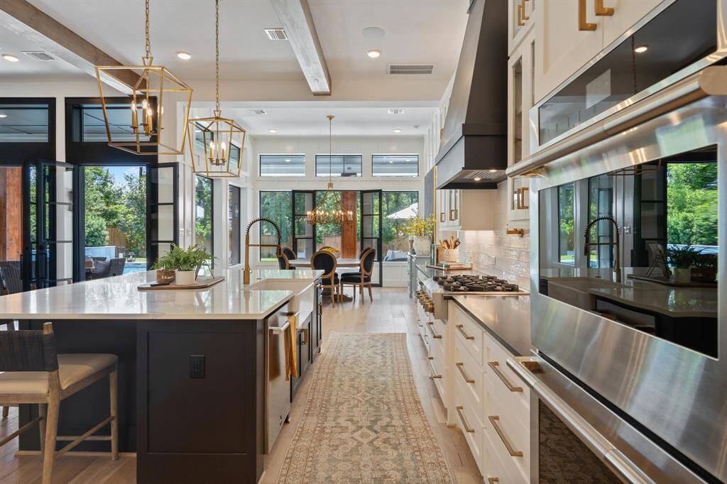 This photo captures a stunning view down the heart of the kitchen toward the breakfast area and backyard.