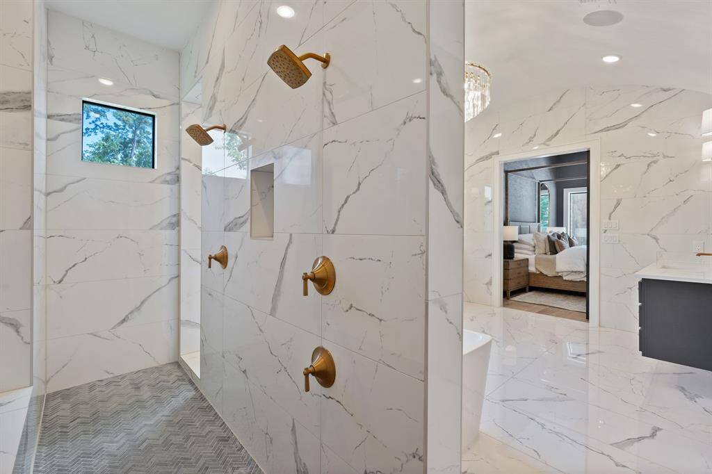 Luxury at its finest—this expansive double-entry shower offers a  rain shower head, dual shower heads and built-in niches for a truly spa-like experience.