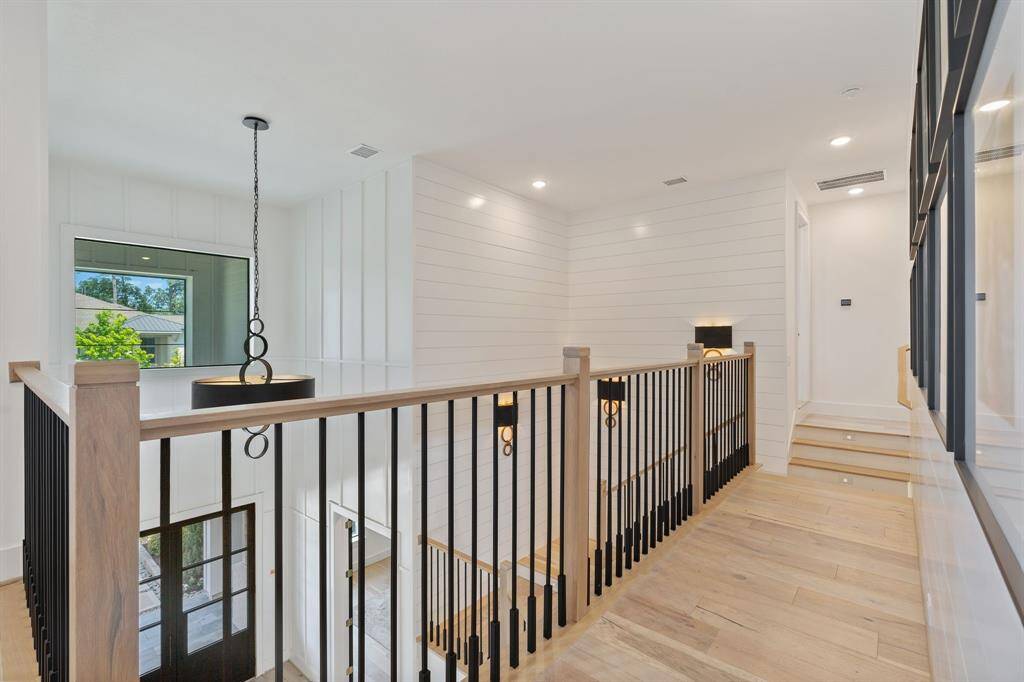 Bright and airy upstairs landing with board and batten walls, shiplap walls, custom lighting, and sleek black iron railing. Upstairs also has 10 ft ceilings and 8 ft doors.