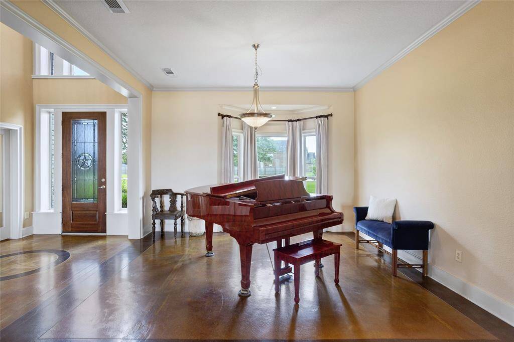 The dining room boasts polished stained concrete flooring and a large bay window that fills the space with an abundance of natural light, creating a bright and inviting atmosphere.