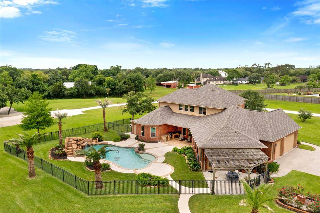 Stunning 1-acre waterfront home with private dock, covered boat slip, and resort-style pool. Spacious backyard with covered patio, lush landscaping, and palm trees. Located in a quiet, upscale, gated neighborhood and beautiful views. Perfect for outdoor living and entertaining.