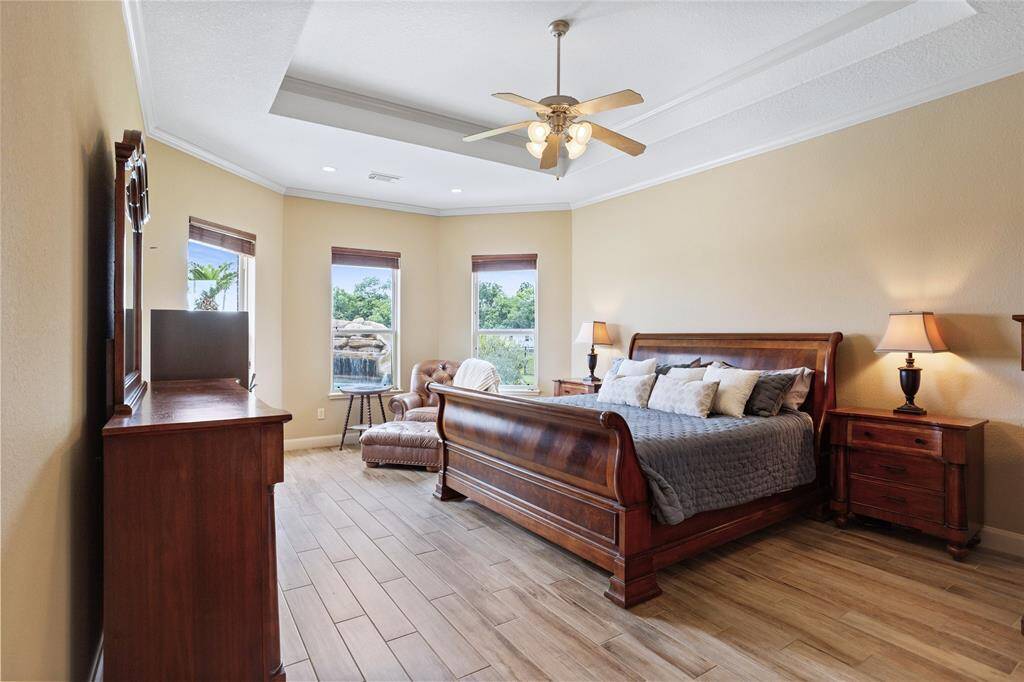 The primary retreat boasts a sitting area, 10-foot ceilings, and recessed lighting, creating a serene and inviting atmosphere.