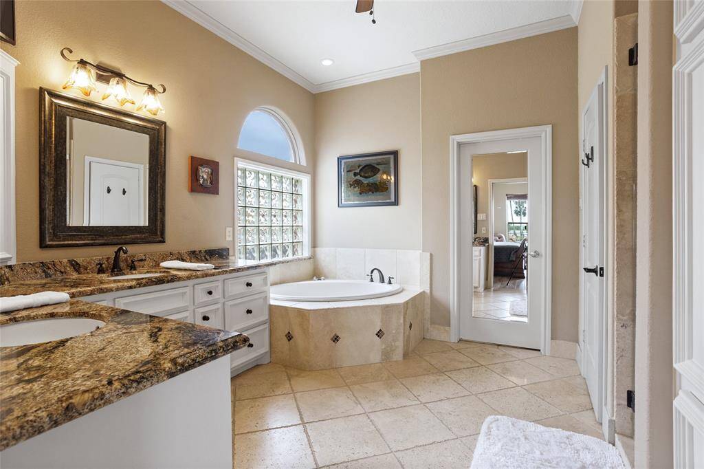 The mirrored door opens to the oversized walk-in closet, which is equipped with a built-in organizational system and additional storage space cleverly tucked away under the stairs.