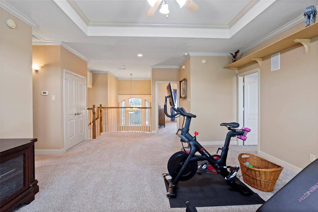 Another view from the Gameroom looks back at the stairs, where a wooden railing overlooks the entryway, adding an elegant touch and enhancing the open, airy feel of the space.