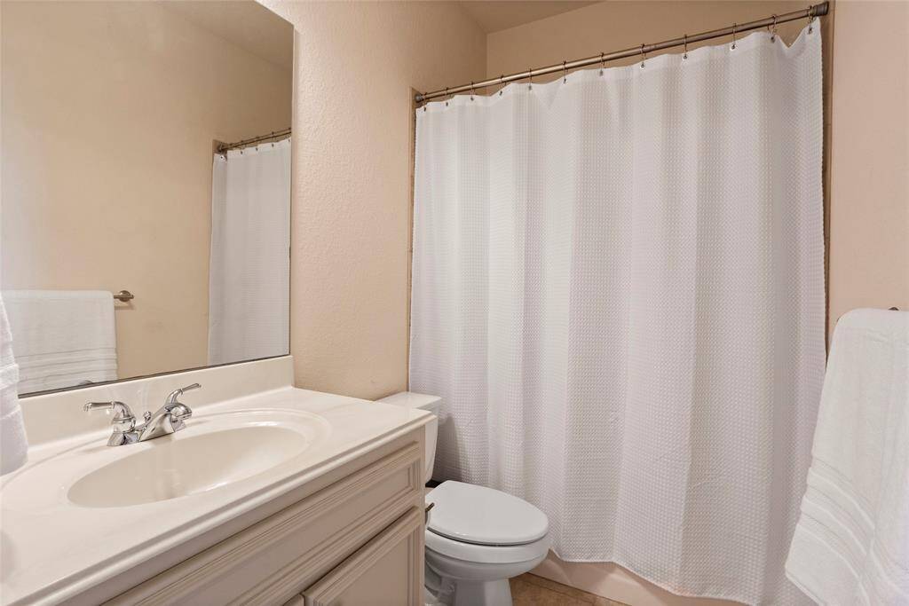 The upstairs ensuite full bathroom features a clean design with a white sink and vanity, creating a bright and refreshing space.