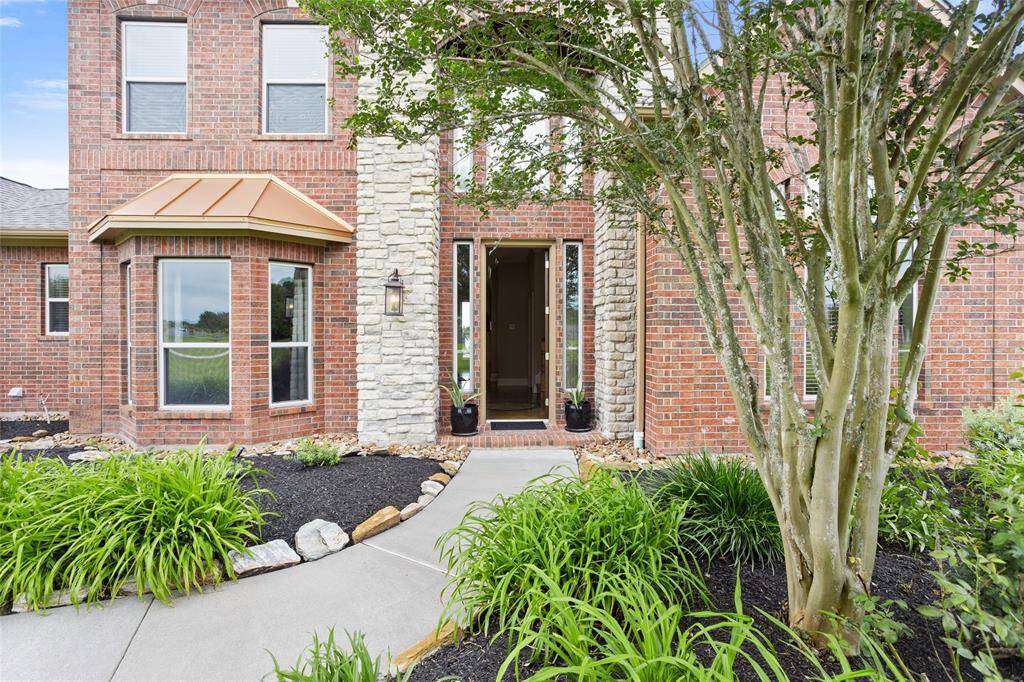 Welcome to this charming brick and stone home, where a beautifully landscaped front yard and inviting pathway create a warm first impression.  A distinctive copper awning adds a touch of timeless elegance to the façade.