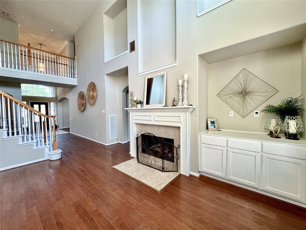 Gas Log Fireplace, built-in cabinetry, and decorative art niches.
