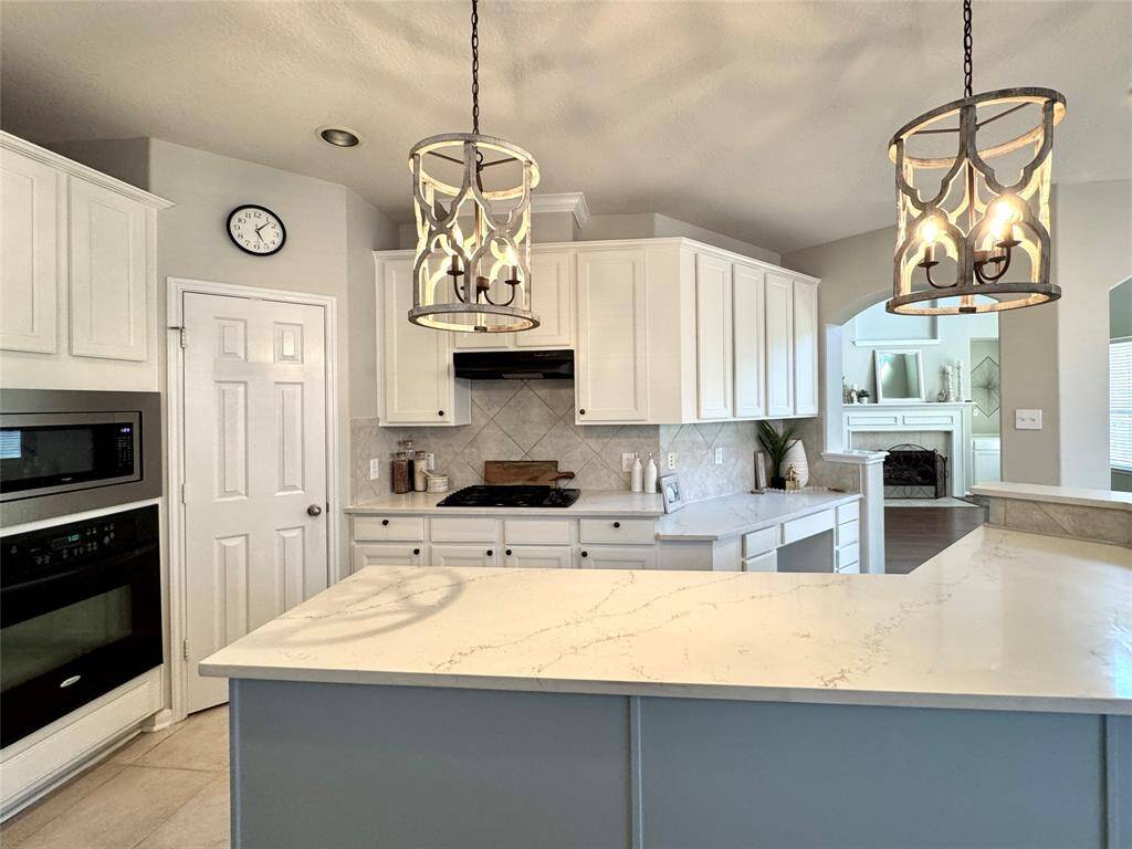 Kitchen w/ wall oven & microwave and gas cooktop.