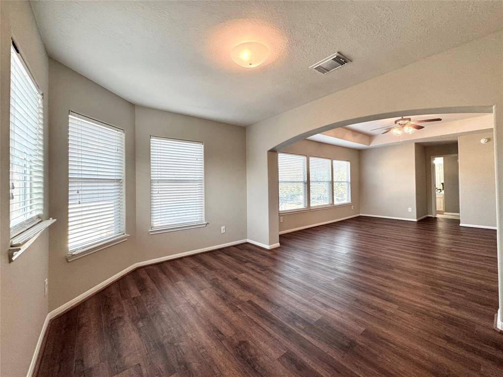 This spacious 2nd floor Game Room features abundant natural light, rich wood flooring, and an elegant archway that allows you to create separate functional spaces.