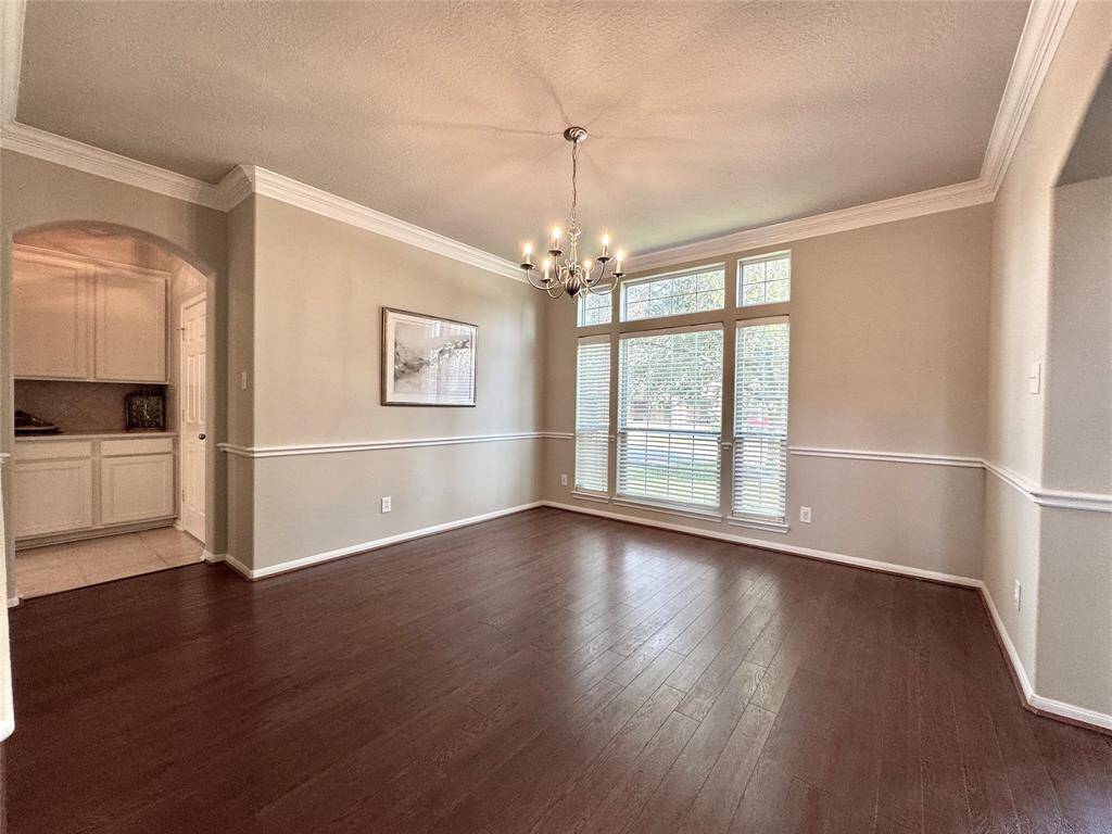 Formal Dining Room featuring wood floors, crown molding & chair rail, and a butler's pantry. Can easily accommodate a large table.
