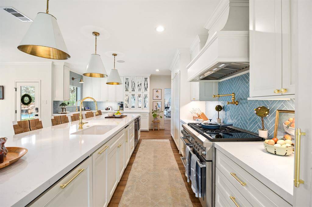 The backyard features a large, inviting pool and spa with stone accents and a waterfall, surrounded by mature trees and a well-maintained patio. The modernized two-story home provides a scenic backdrop, offering plenty of outdoor space for relaxation and entertainment.