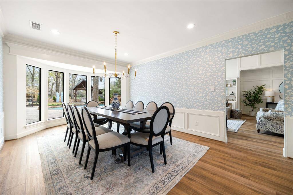 The expansive dining area is perfect for hosting, with five large windows offering serene views of the pool and filling the space with natural light.