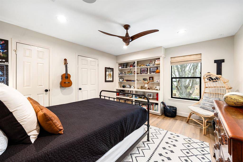 One of four secondary bedrooms upstairs, this room offers stunning views of the backyard, a spacious walk-in closet, and convenient access to the walk-in attic.