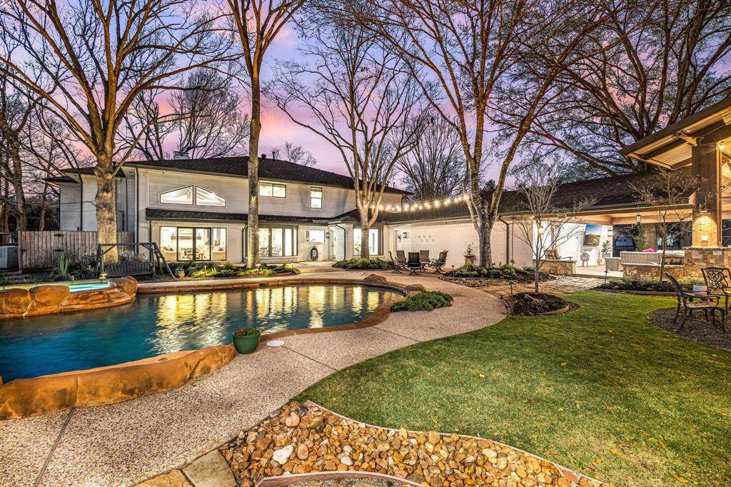 Enjoy this spacious backyard with a large pool and spa, surrounded by mature trees and a well-maintained, custom-designed garden. The home features a side porch and an outdoor seating area perfect for entertaining a large crowd. The setting is serene with thoughtfully placed lighting to enjoy your evenings.