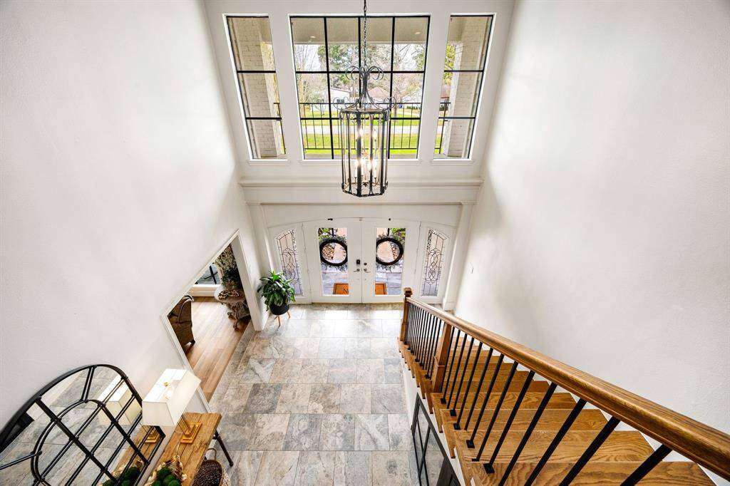 A formal entry with soaring ceilings leads into the main living room. The travertine flooring in the foyer adds elegance, while recently replaced windows fill the home with abundant natural light.