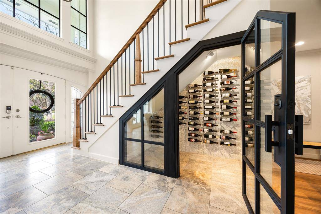 A stylishly designed wine closet is conveniently nestled under the stairs, offering a sophisticated space to store and showcase your favorite vintages. Perfect for wine enthusiasts, this thoughtfully placed feature adds both elegance and functionality to the home.