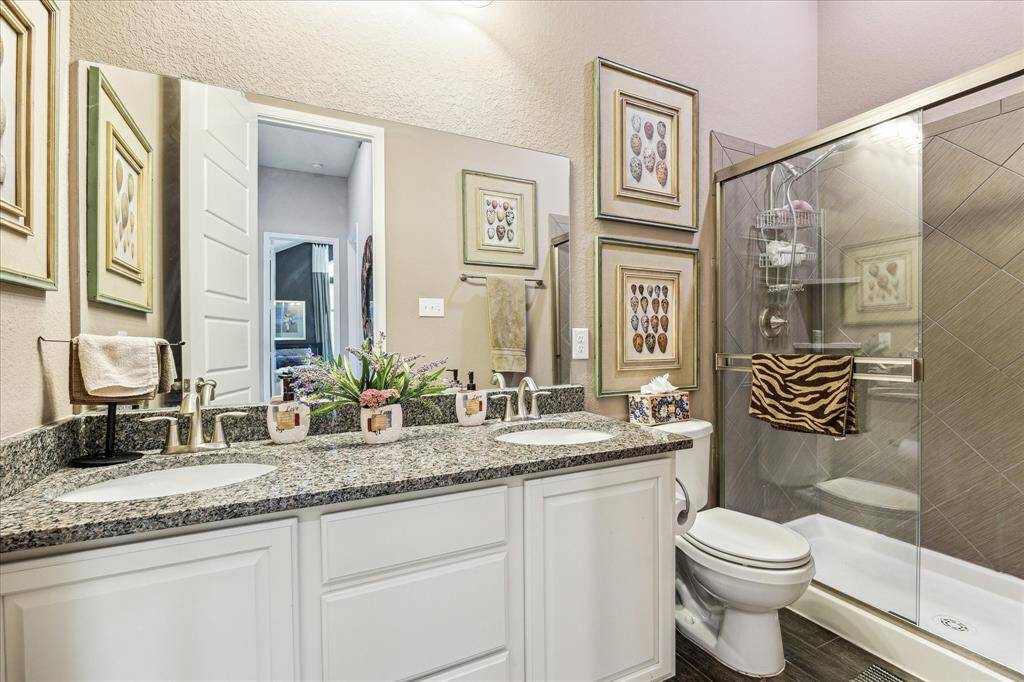 Secondary bathroom equipped with dual sinks and a beautiful walk-in shower.