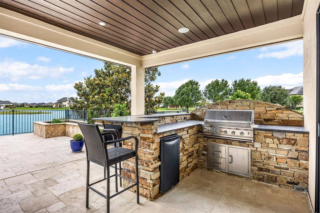Situated on the end of your covered back patio near the spa is the outdoor kitchen with granite counters, a gas grill and sit-up eating bar.
