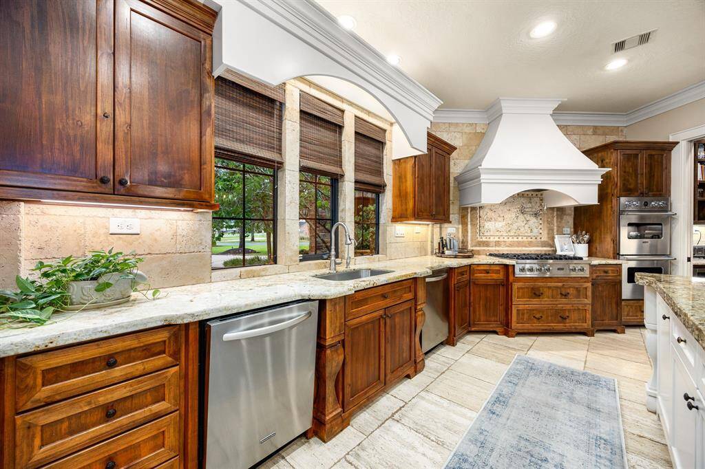 The gourmet kitchen boasts high-end appliances, granite countertops, and 2 large islands ideal for entertaining.