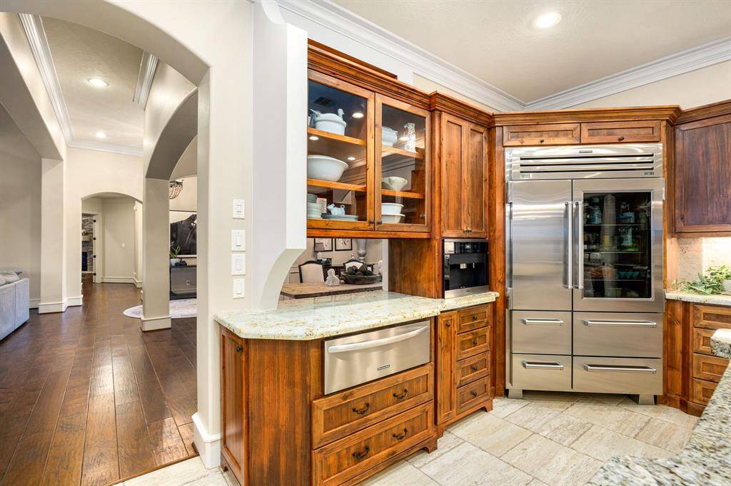 The rich wood cabinetry with warm finish contrasts beautifully with the crisp white base of the island. You'll be impressed with the professional grade refrigerator, three ovens, a warming tray and Miele coffee maker.