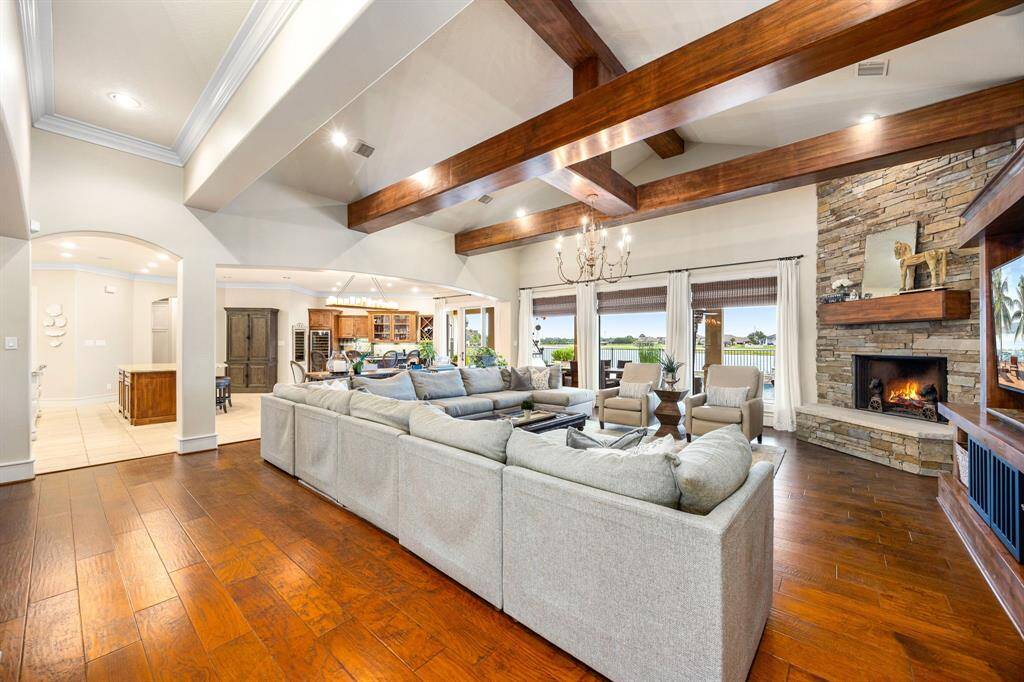 A spacious great room with high ceilings and a stone fireplace opens onto a covered patio, perfect for post-ski relaxation or evening gatherings.