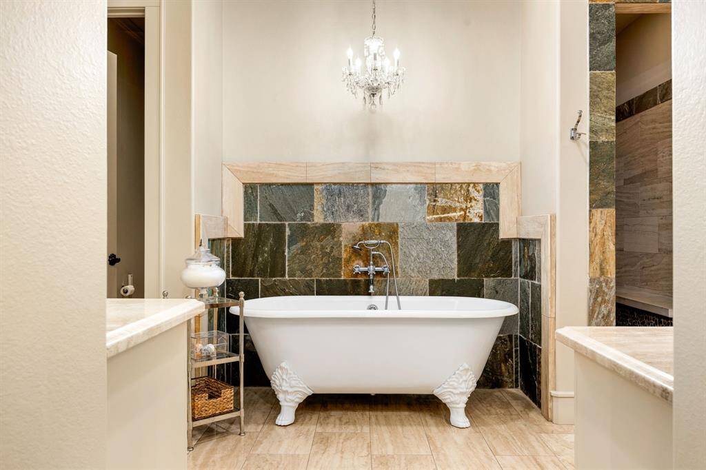 The primary retreat has a standalone claw tub, offering a touch of vintage charm. Just behind it, you'll find a spacious walk-in shower.
