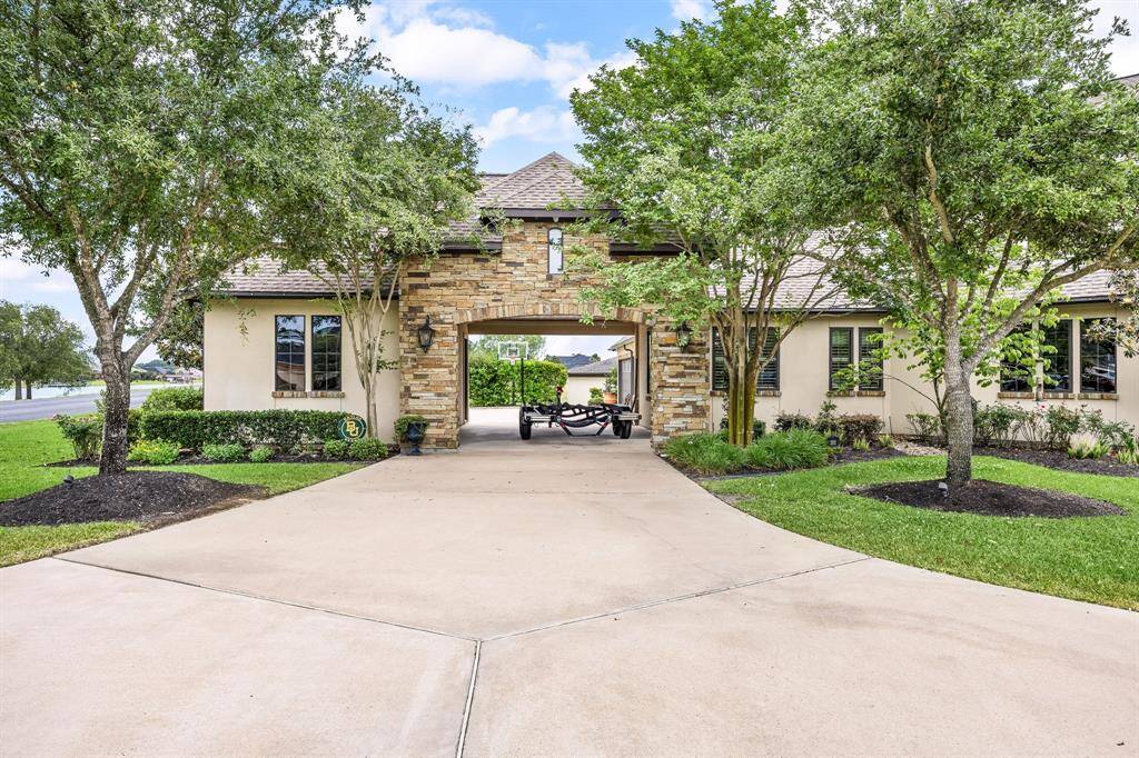 A spacious fifth garage bay and elegant porte-cochere offer seamless access to four additional garage bays, ideal for accommodating multiple vehicles or creating a versatile storage and workspace area.