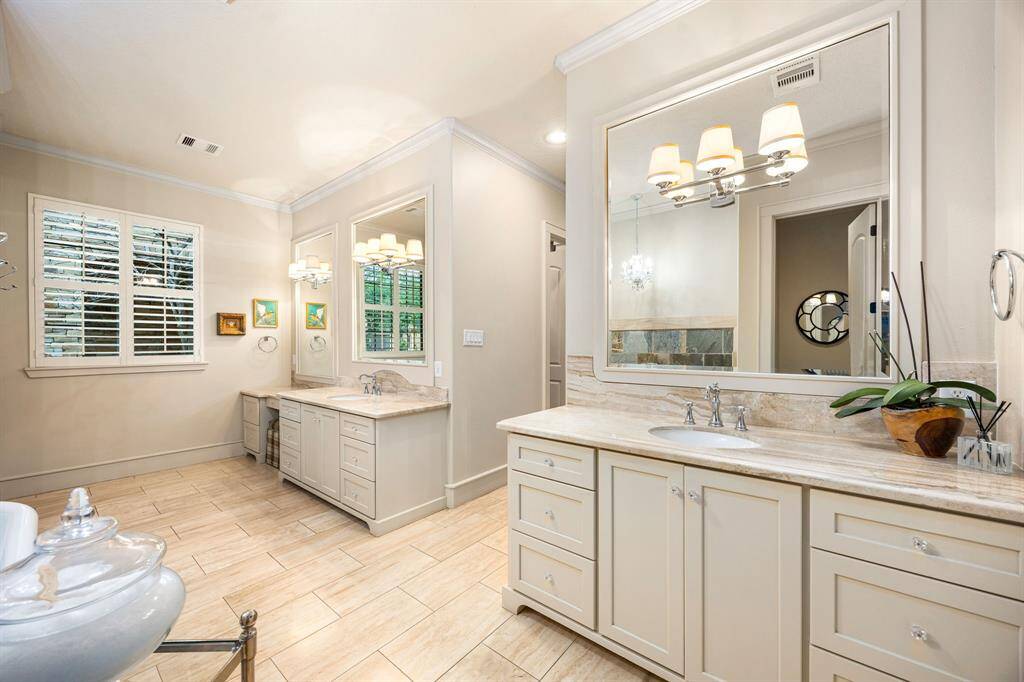 The primary bath offers plenty of storage and features two walk-in closets. Dual sink areas and a dedicated vanity space add both convenience and style.
