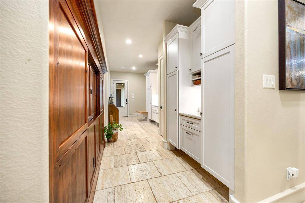 This hallway connects the back door to the mudroom with plenty of storage for shoes and coats. Plus, there's a clever passthrough on the left which leads right into the pantry—perfect for unloading groceries without missing a beat.