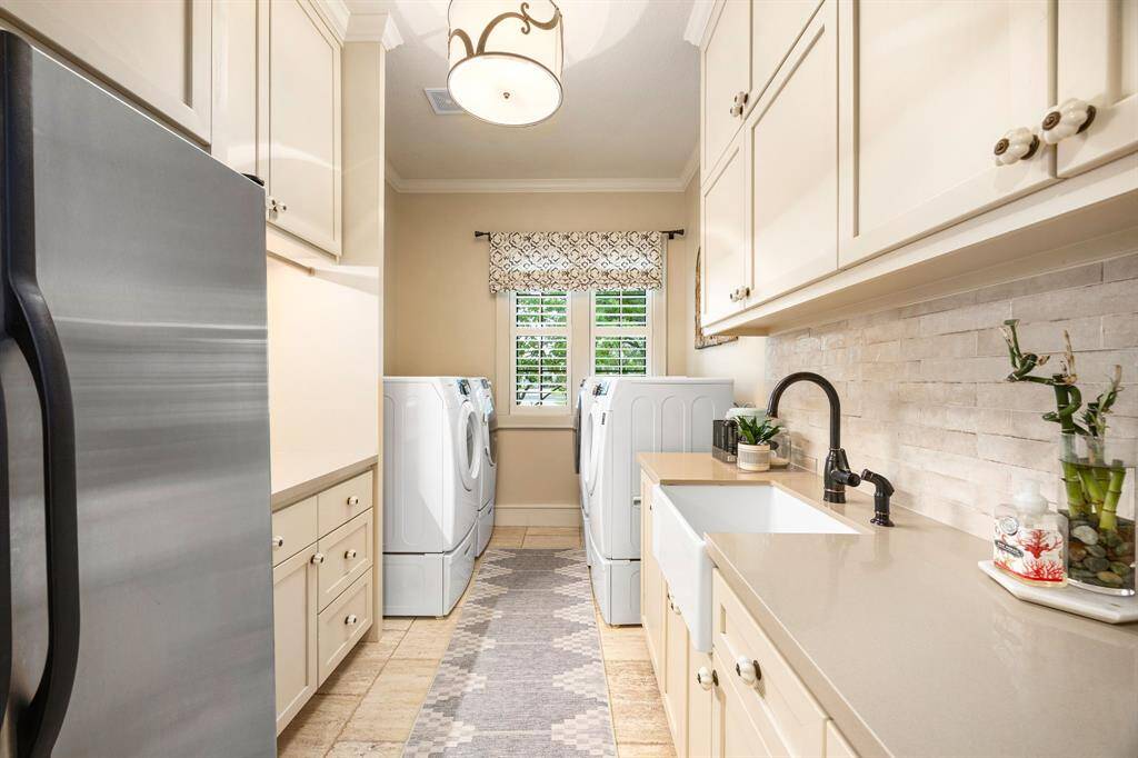 You will love this large laundry room complete with a utility sink and ample folding space. The two sets of washers and dryers are available for purchase.