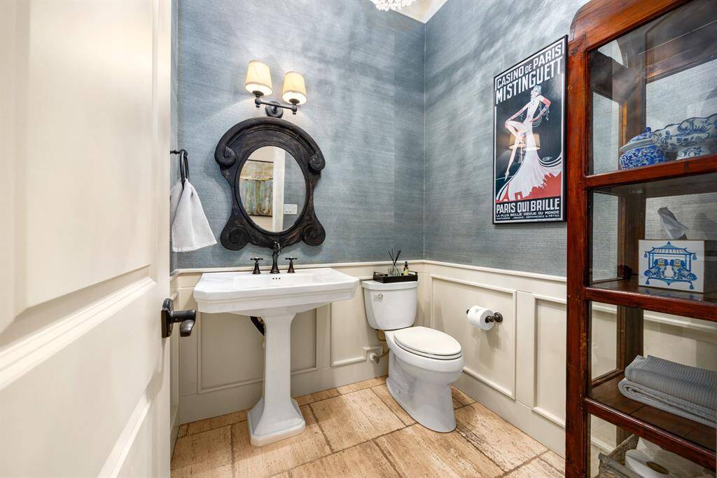 Custom wallpaper accentuates this spacious half bathroom.