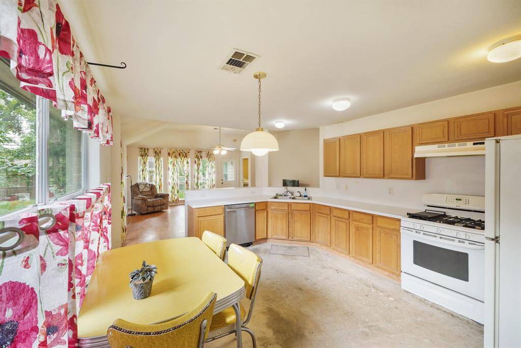 Virtually Cleaned: This open kitchen has great illumination, carpet floors, tons of counterspace, and wooden cabinetry.