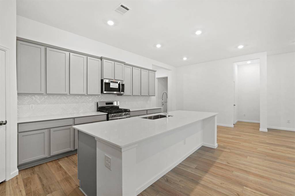 Gourmet Kitchen with recessed lighting, new appliances and hardwood flooring.