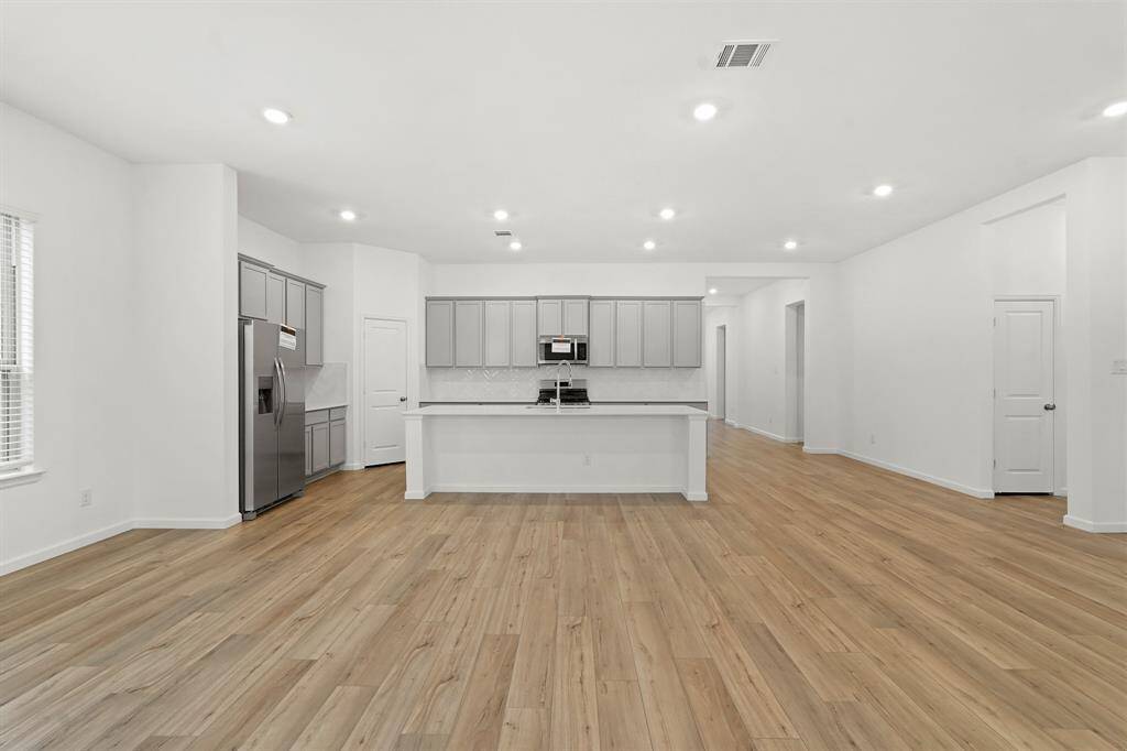 View from Dining Area showcasing the hardwood flooring, recessed lighting, and elegant space to host dinners just off the Kitchen.
