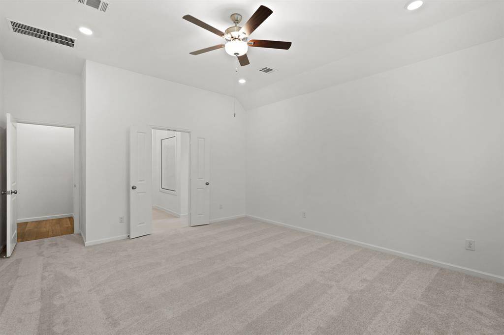 Primary Suite Oasis with plush carpeting and ceiling fan with lighting.